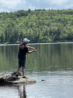 Man fishing from rocks.