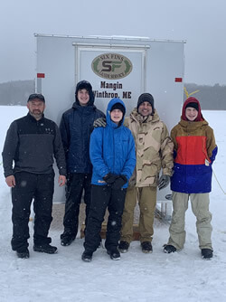 Group photo of adults and teenagers before starting ice fishing.