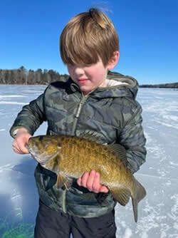 Boy holding the Smallmouth Bass he caught.