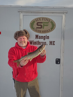 Happy man holding the Lake Trout he caught.