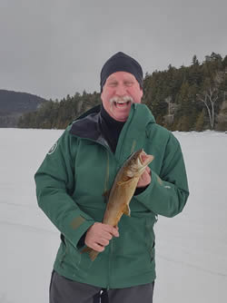 Man laughing with the Lake Trout he caught.