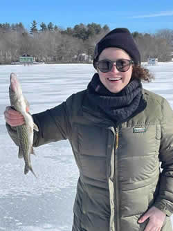 Happy woman holding a Chain Pickerel she caught with Six Fins Guide Service.