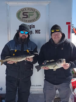 Two men holding a Largemouth Bass and Chain Pickerel they caught.