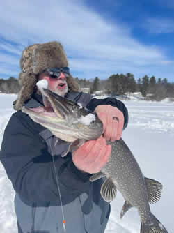 Man holding a large Northern Pike he caught.