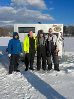 Group photo of four men who have been ice fishing.
