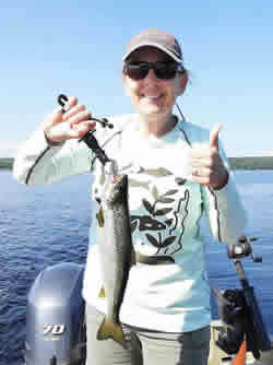 Woman holding the Salmon she caught.