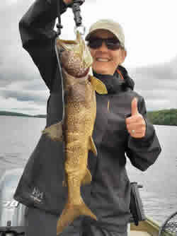 Woman holding a Lake Trout she caught.